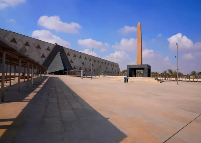 Modern architectural exterior of the Grand Egyptian Museum GEM in Giza on a clear sunny day.