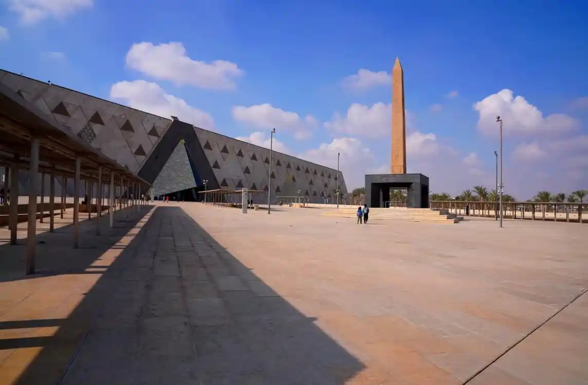 Modern architectural exterior of the Grand Egyptian Museum GEM in Giza on a clear sunny day.